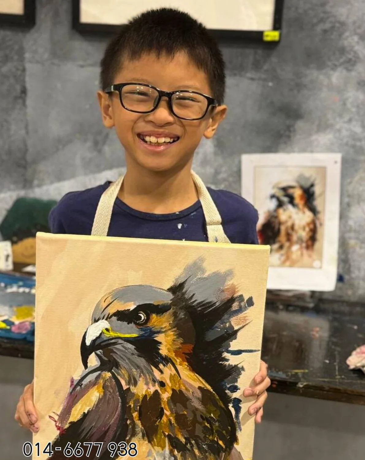 Boy holding dramatic animal painting from Rycca art class