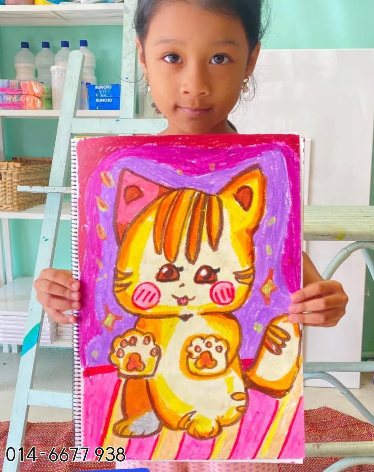 Girl holding cute character painting from Rycca art class