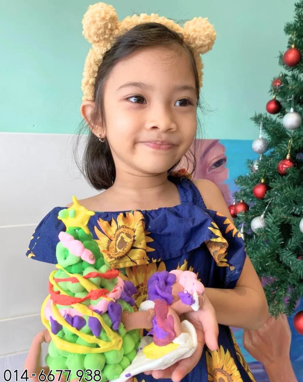 Young girl holding sunflower texture art from Rycca art class